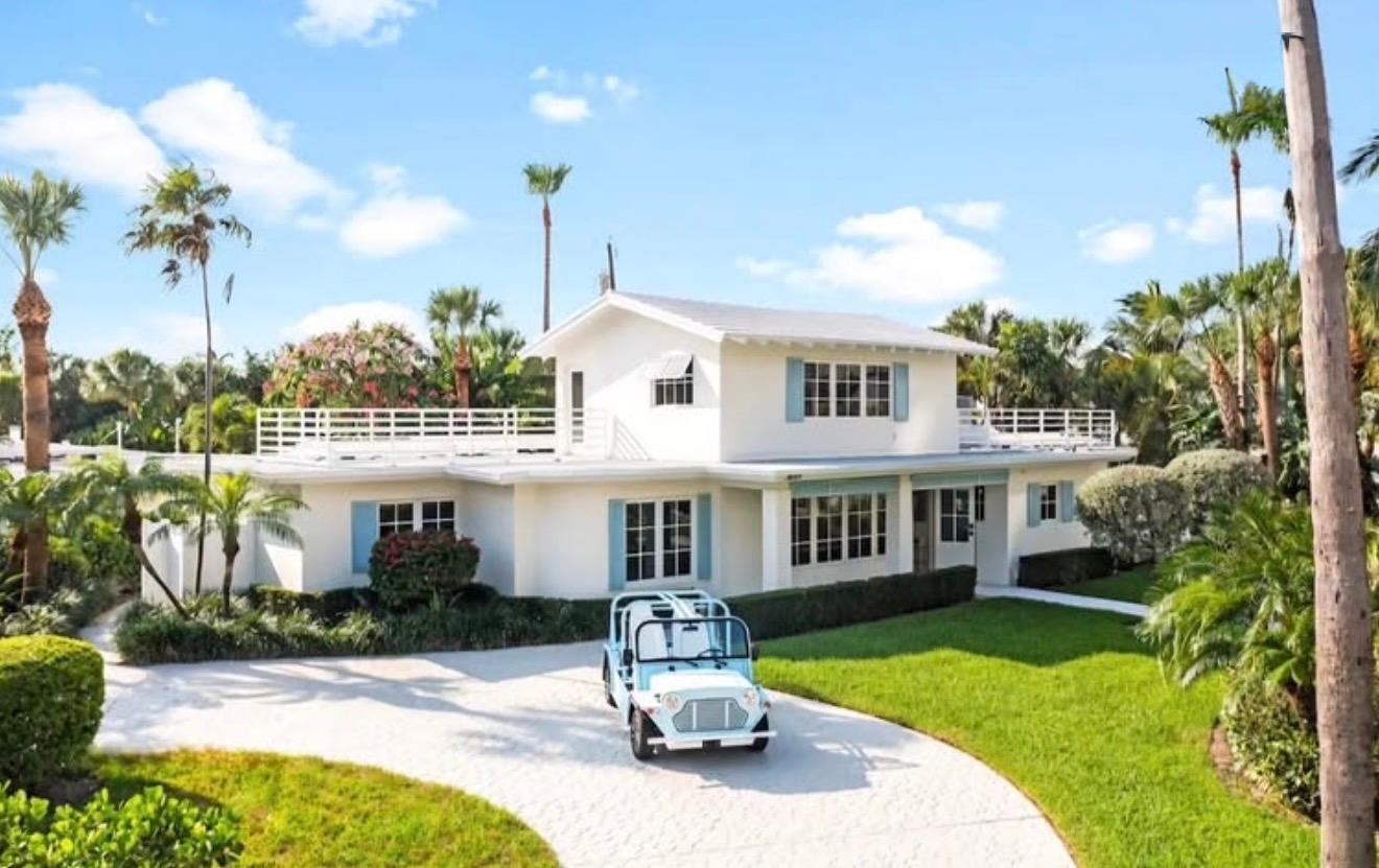 White two-story Florida home with blue shutters and large impact-rated windows